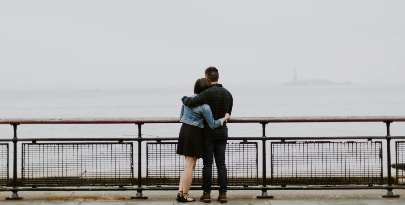 A couple hugging while looking at the ocean