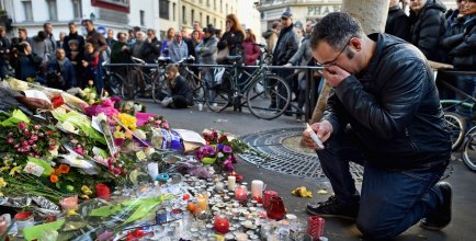 public gather to lay flowers and light candles following a suicide bomber attack