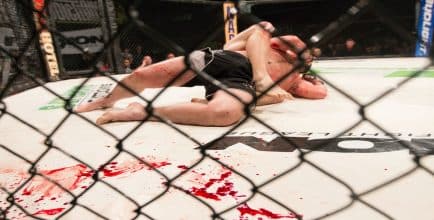 two MMA fighters on a bloody mat.