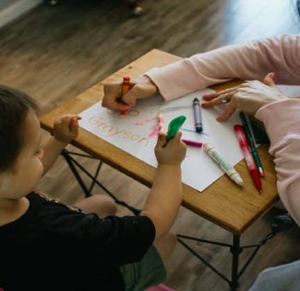 A kindergartener drawing at his desk